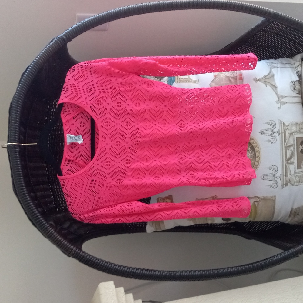 Pink long sleeve top with small cut outs throughout concealer for bust area.